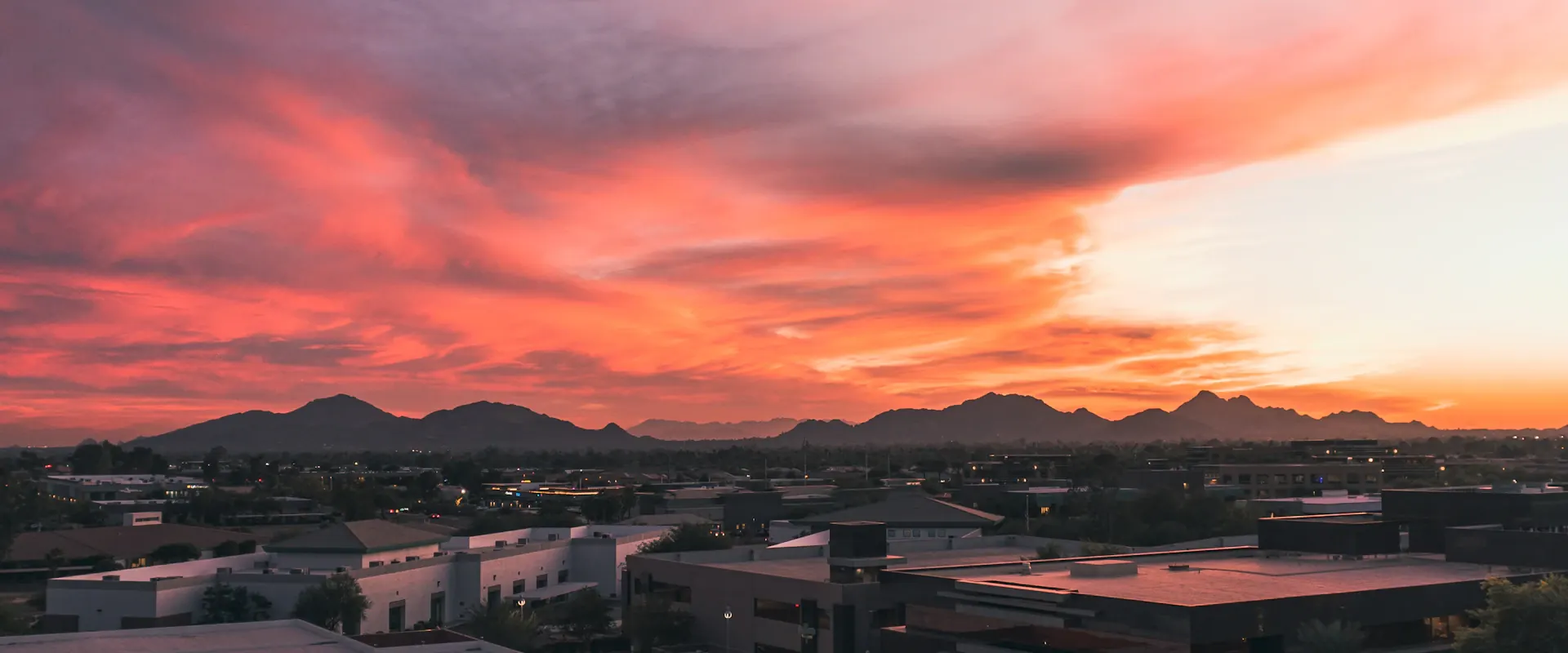 Phoenix skyline and desert mountains beneath a vivid sunset